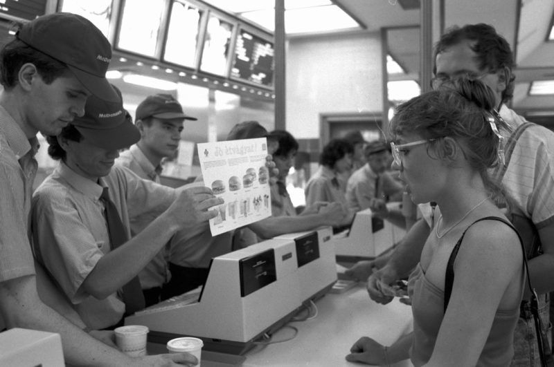 Budapest, 1988. július 5. A választékot kínálja egy eladó az elsõ McDonald's étteremben a belvárosi Régiposta utcában. Az 1988. április 29-én megnyílt elsõ McDonald's gyorsétterem nagy sikerrel üzemel. A csak hazai alapanyagokra épülõ vállakozás létrehozója a Bábolnai Mezõgazdasági Kombinát és a McDonald's közös vállalata. MTI Fotó: Cseke Csilla