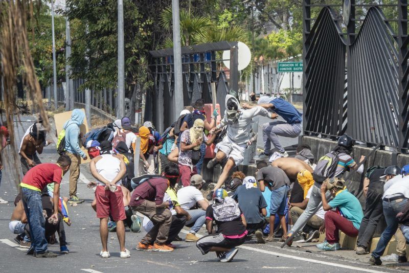 Opposition demonstrators run out of the military base La Carlota, which they entered after destroying the fence, when the National Bolivarian Guards, military police, charged, during the May 1st demonstration organized by the opposition in Caracas. Caracas, Venezuela. May 1st, 2019. Les manifestants de l'opposition se sont enfuis de la base militaire La Carlota, où ils sont entrés après avoir détruit la clôture, lorsque la Garde nationale bolivarienne, une police militaire, les a chargés, lors de la manifestation du 1er mai organisée par l'opposition à Caracas. Caracas, Venezuela. 1er mai 2019.