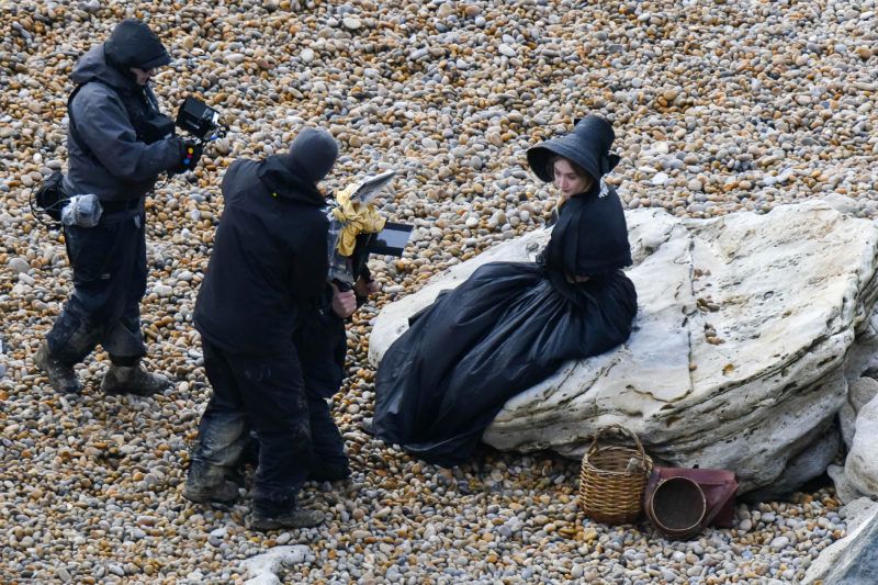 BNPS.co.uk (01202 558833) Pic: Graham Hunt/BNPS Saoirse Ronan filming a scene on the Beach at Eype near Bridport in Dorset yesterday for the new film Ammonite about the life of fossil hunter Mary Anning. Saoire Ronan being filmed sitting on a rock. March 14, 2019 ***EXCLUSIVE***