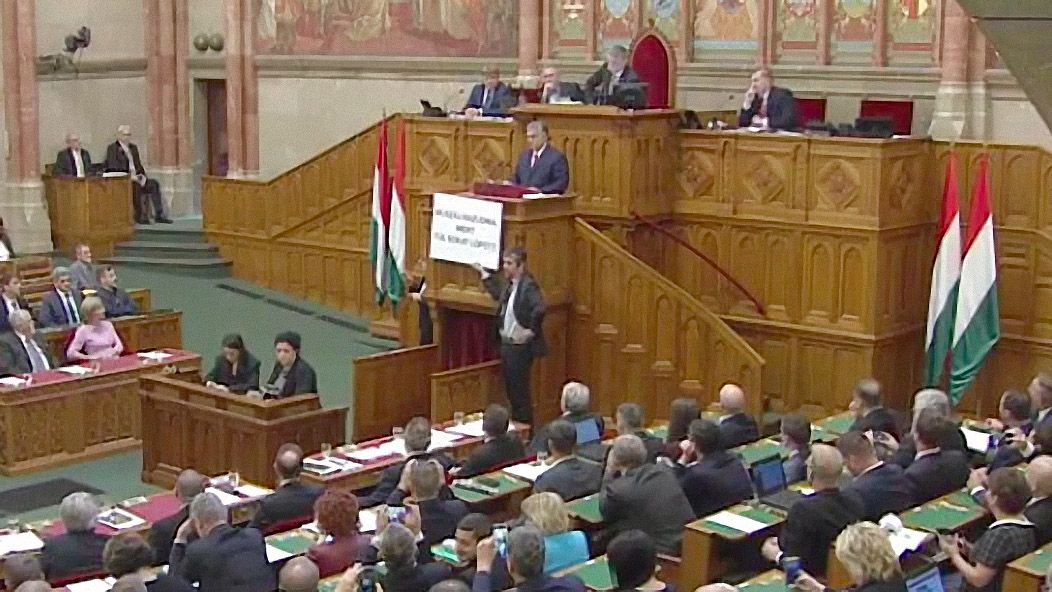 Hadházy táblával hekkelte meg Orbán beszédét: Muszáj hazudnia, mert túl sokat lopott