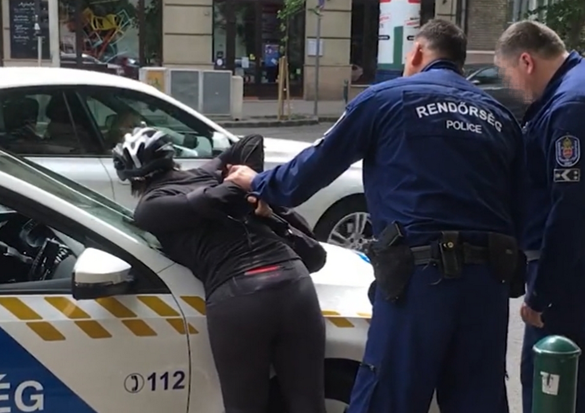 Rendőrautóra tepertek és megbilincseltek egy piroson áthajtó biciklis nőt Budapesten