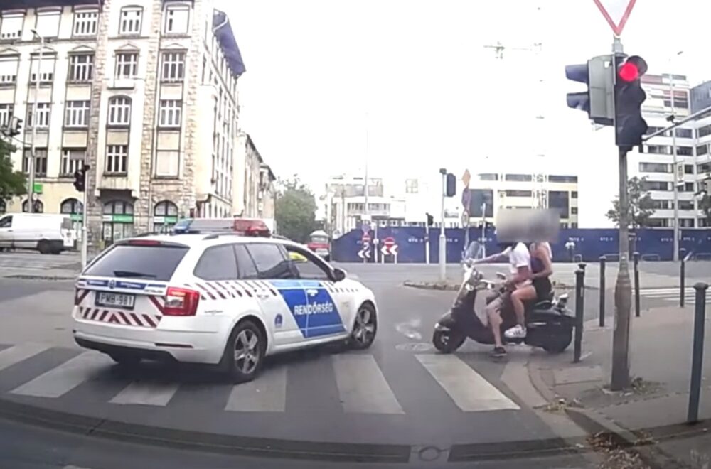 Videón, ahogy robogóval menekül a rendőrautó elől egy fiatal fiú és lány utasa Budapesten
