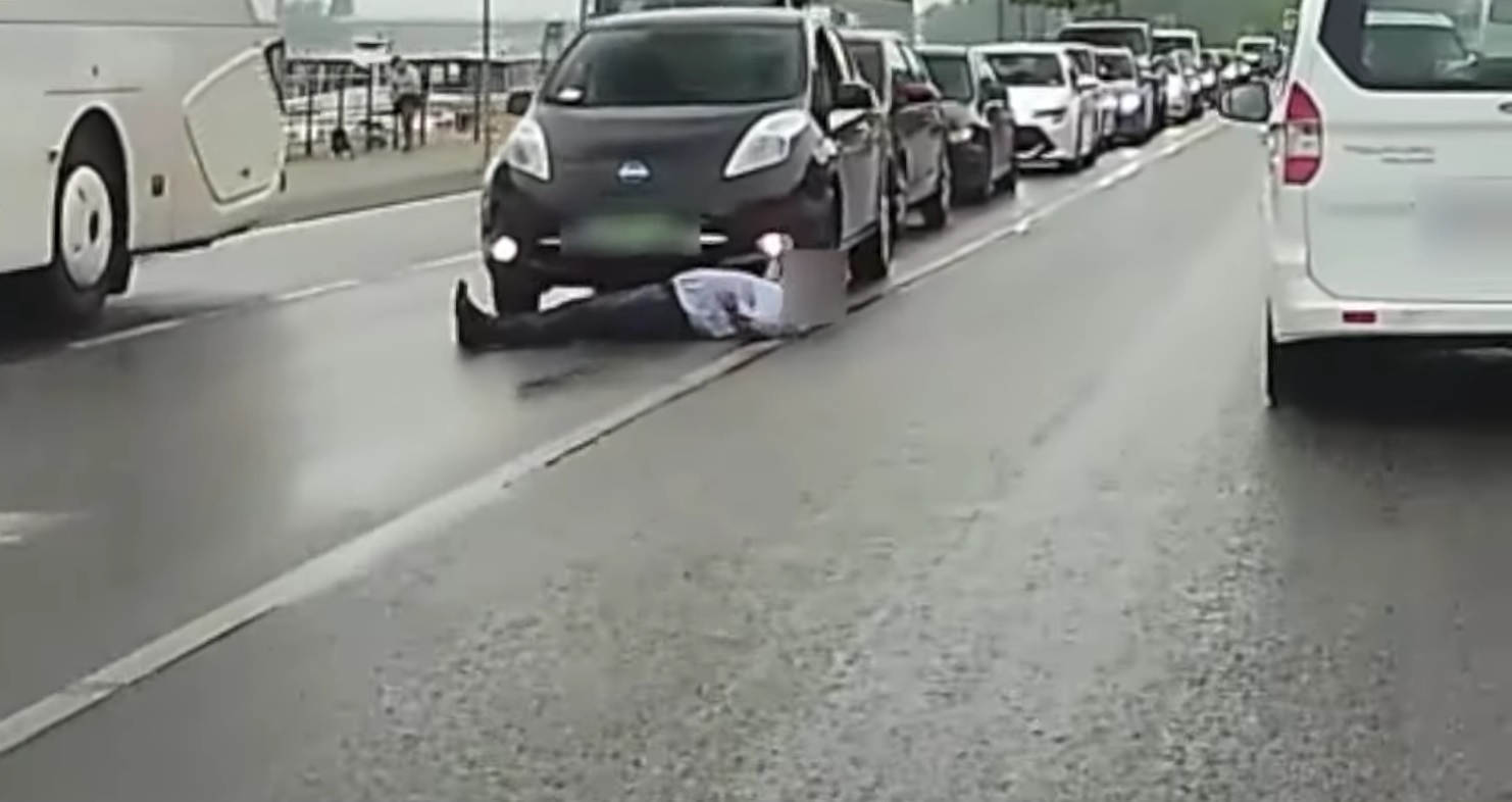 Elképesztő videó: az út közepén hanyatt fekve állta útját az autóknak egy férfi a rakparton